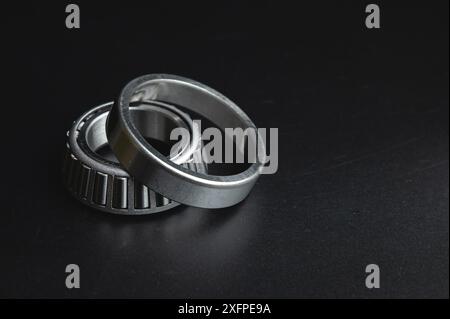 New two-piece roller bearing on a black background. Metal spare part for car suspension Stock Photo