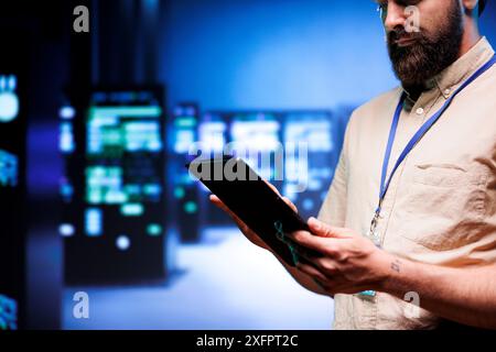 Specialist inspecting interlinked computers creating server network. Cloud computing service business using parallel computing to perform complex calculations and process large amounts of data Stock Photo