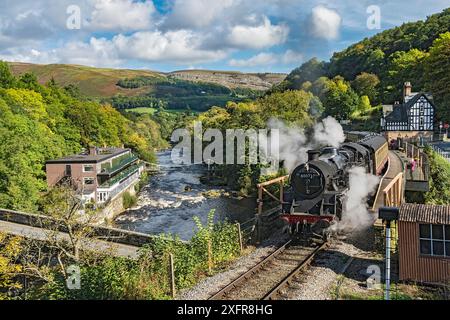 Steam train leaving Berwyn station beside the River Dee and the Chainbridge Hotel on the Llangollen Heritage Railway  to Corwen North Wales, UK, September 2017. Stock Photo