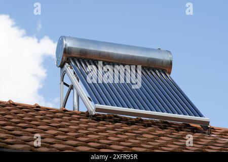 solar water heater on a roof top, solar water heating panel, blue sky in the background Stock Photo