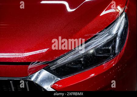 Close-up of a red car headlight with vinyl wrap.  Stock Photo