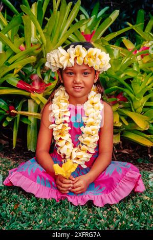 A young Hawaiian girl (model released) wearing a plumeria flower lei, Hawaii. Stock Photo