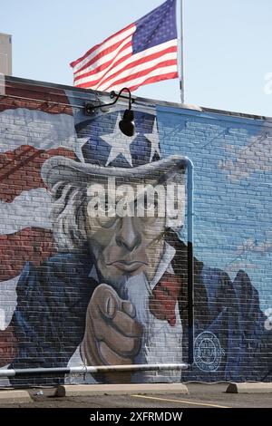 St. Louis, United States. 04th July, 2024. An American flag flys above a mural of Uncle Sam on the side of a building in Sunset Hills on Thursday, July 4, 2024. Photo by Bill Greenblatt/UPI Credit: UPI/Alamy Live News Stock Photo