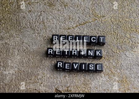 Concept of Reflect, Rethink, revise written on wooden blocks. Cross processed image on Wooden Background Stock Photo