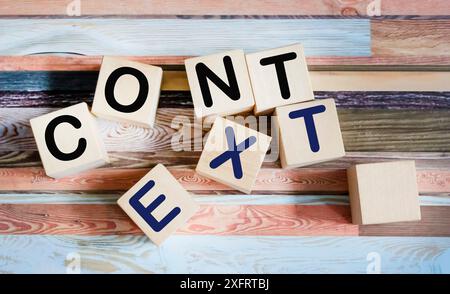 CONTEXT The word is written on wooden cubes and vintage background. Stock Photo