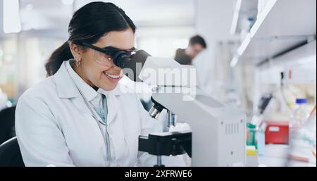 Medical, biotech and woman with microscope, science and check experiment for breakthrough. Research, scientist and employee with lab equipment, DNA Stock Photo