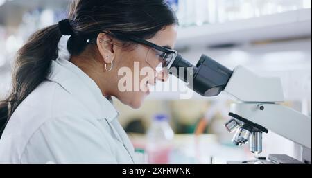 Medical, research and woman with microscope, biotech and check experiment for cancer treatment. Person, science and employee in lab, vaccine and Stock Photo
