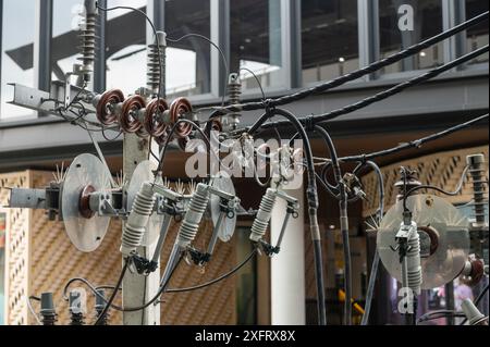 Power lines and insulators with high voltage fuses mounted on electric pole Stock Photo