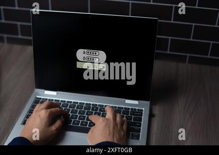 A close-up image of a person's hands typing on a laptop computer with a login screen visible on the monitor. Cyber security and digital security conce Stock Photo