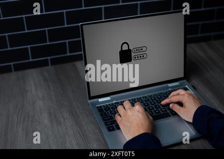 A close-up image of a person's hands typing on a laptop keyboard with a lock symbol on the screen. Cyber security and digital security concept. Stock Photo