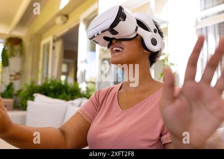 Using VR headset, woman enjoying virtual reality experience at home Stock Photo