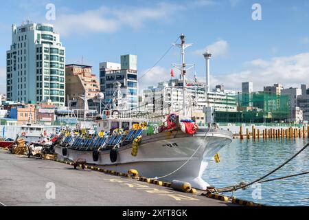 Busan, South Korea - October 7, 2017: Beautiful view of fishing vessel parked at the Port of Busan on sunny day. Scenic cityscape. Stock Photo