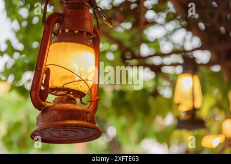 Old street lights on green foliage background. Vintage style lighting. Amazing decor. Stock Photo