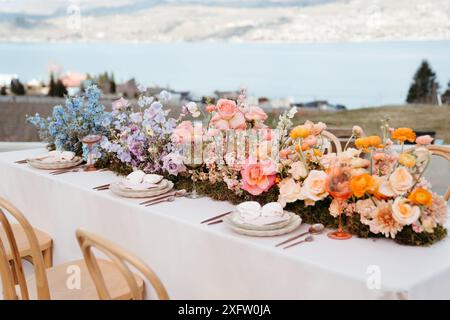 Vibrant florals and colorful place setting on wedding table Stock Photo