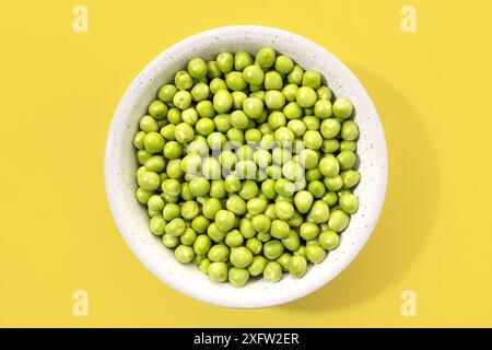 Top view of Fresh green peas in bowl isolated on yellow background Stock Photo