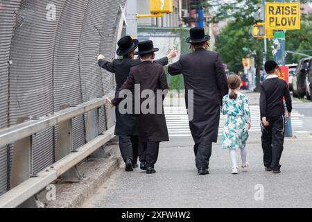 A view from behind of a Hasidic father & 4 children walking south on Lee Avenue in Williamsburg, Brooklyn, New York. Stock Photo