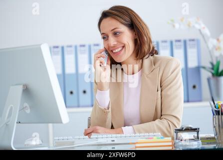 Executive woman in office talking by phone. Stock Photo