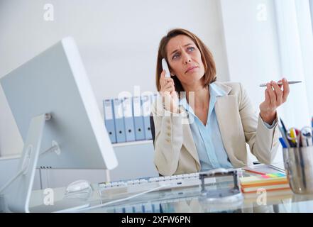 Executive woman in office talking by phone. Stock Photo