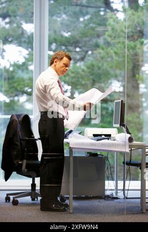 Architect with blueprints in office Stock Photo