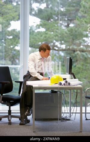 Architect with blueprints in office Stock Photo
