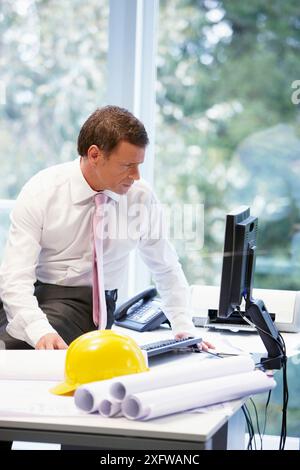 Architect with blueprints in office Stock Photo