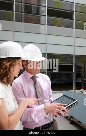 Architect and client with tablet PC in construction site Stock Photo
