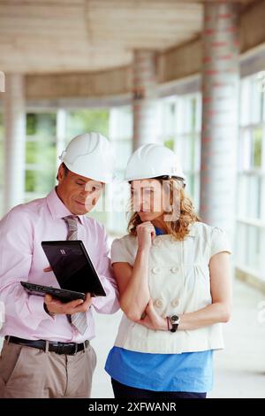 Architect and client with tablet PC in construction site Stock Photo