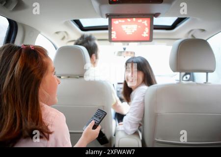 Family travelling, girl watching DVD in car Stock Photo