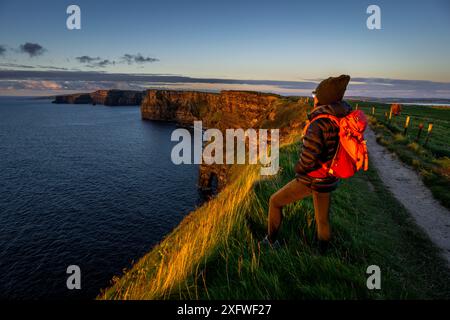 Cliffs of Moher, cliffside hiker, The Burren, County Clare, Ireland, United Kingdom. Stock Photo