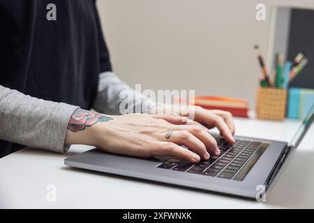 Cropped hands of businesswoman typing on laptop while working at office Stock Photo