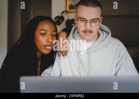 Young male and female entrepreneurs working on laptop at home Stock Photo