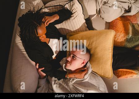 Directly above shot of couple spending leisure time on sofa at home Stock Photo