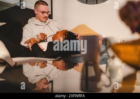 Smiling multiracial couple spending leisure time talking to each other at home Stock Photo