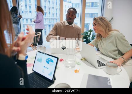 Multiracial group of business colleagues sharing ideas while working in office Stock Photo