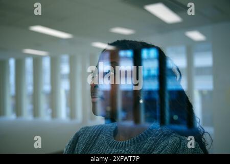 Close-up of young businesswoman day dreaming in office seen through glass window Stock Photo