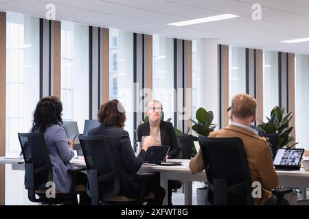 Corporate coworkers discussing over conference table in office Stock Photo
