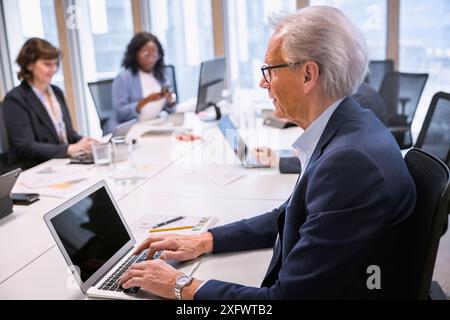 Senior businessman using laptop while working in office Stock Photo