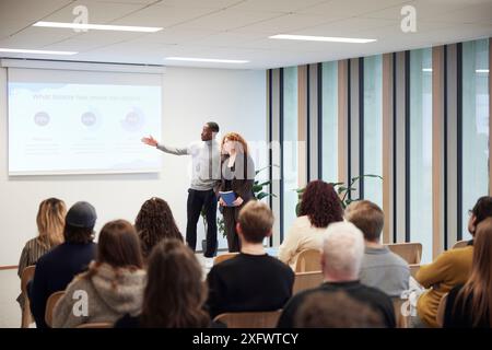 Multiracial coworkers giving presentation to colleagues in office Stock Photo