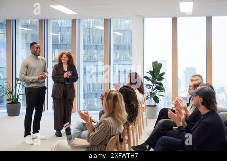 Multiracial business people applauding for achievements during meeting in office Stock Photo