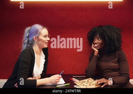 Multiracial female colleagues discussing ideas in office Stock Photo