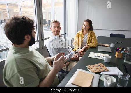 Businessman discussing ideas with coworkers in office Stock Photo