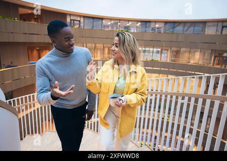 Business colleagues talking while standing on staircase Stock Photo