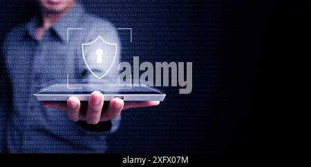 Cyber security data protection. The man uses a virtual digital shield on his tablet computer to protect his personal data and cybersecurity. Safe and Stock Photo