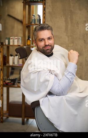 Handsome man with stylish haircut and beard posing looking at camera Stock Photo