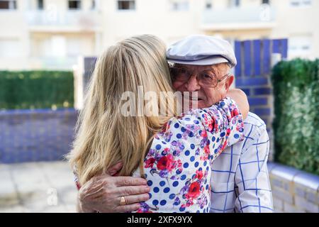 A woman hugs an older father in summertime. family having fun together Stock Photo
