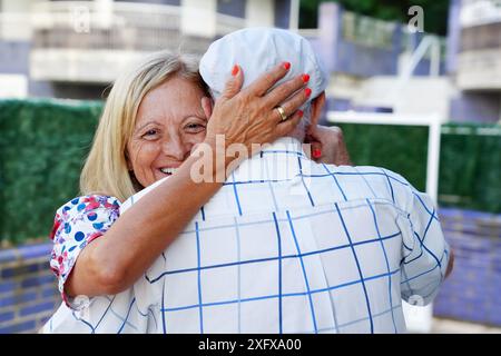 A happy daughter hugs an elderly father outside in summertime. family time Stock Photo