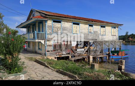 461 Vernacular wooden house of timber planks with porch on stilts above water and sheet metal roof, Cayo Granma Key fishing community. Santiago-Cuba. Stock Photo