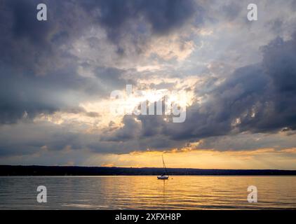 Sunset, sun shines through dark clouds over Lake Ammersee, Bavaria, Germany, Europe Stock Photo