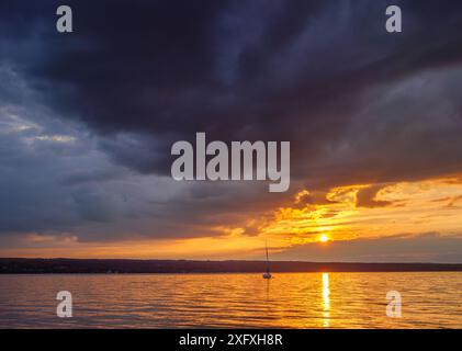 Sunset, sun shines through dark clouds over Lake Ammersee, Bavaria, Germany, Europe Stock Photo