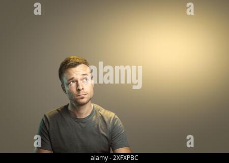 Thoughtful Man Looking Up to the Side with Copyspace Stock Photo